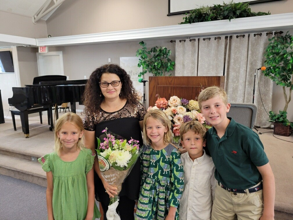 A woman and four children posing for the camera.